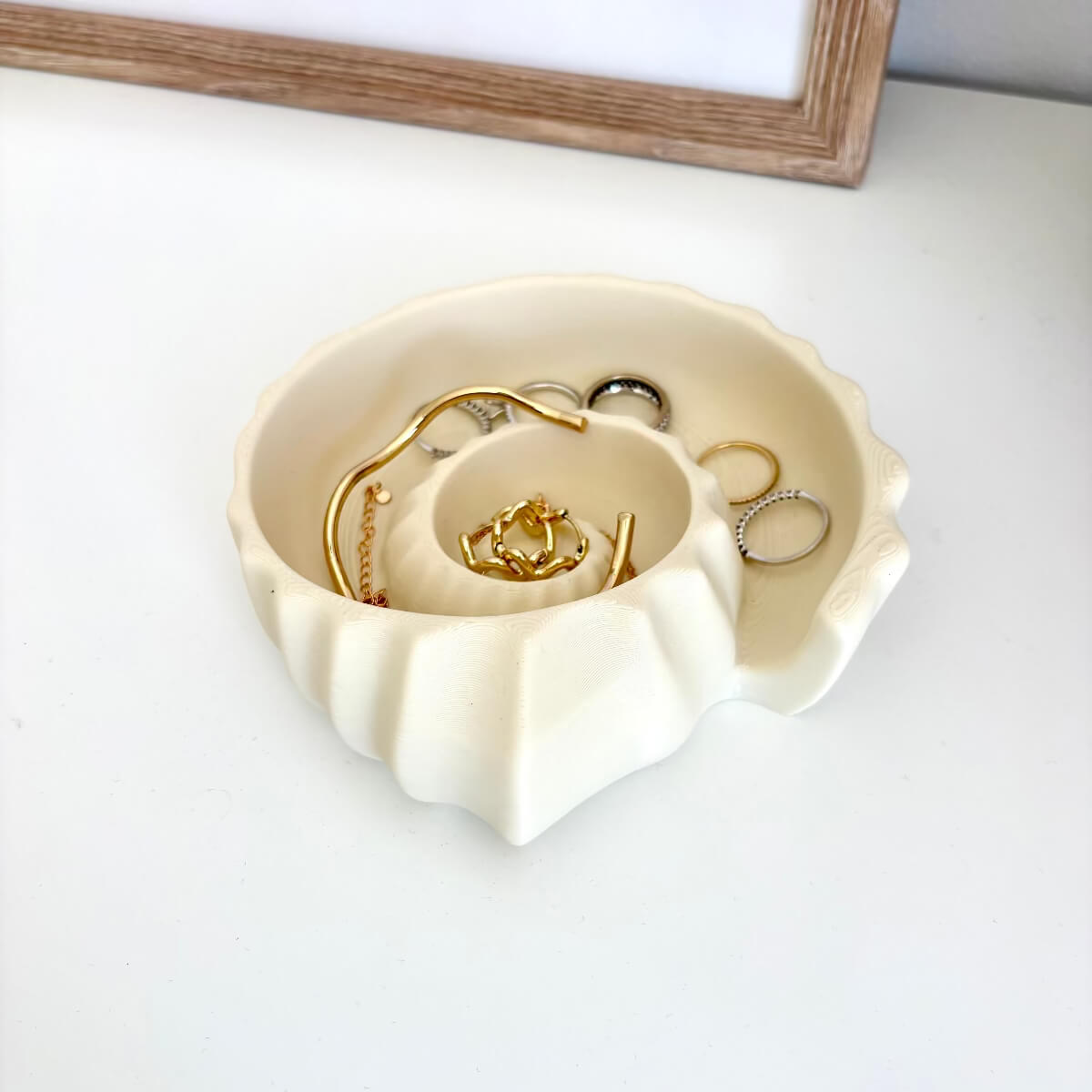 Ammonite Tray 3D printed styled with rings, bracelets and necklaces on a white surface