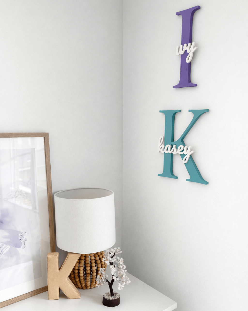 Custom Initial Wall Decor with name styled on a wall next to a shelf with lamp and picture frame